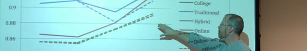 presenter pointing at powerpoint presentation