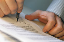 Photo of hands signing an application
