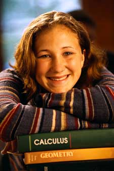 Photo of smiling girl with calculus book.