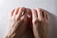 photo: hands reading a braille page