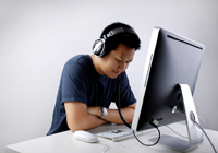 Man with headphones looking at a computer
