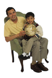 Boy holding globe on dads lap