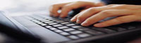 photo of hands typing on a laptop keyboard